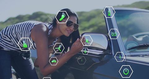 Indian woman leaning and adjusting car mirror with augmented reality icons on roadside