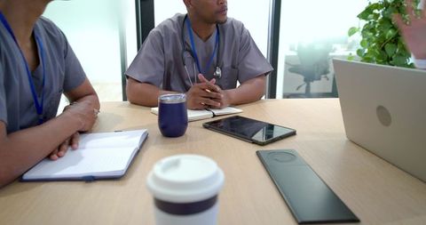 African american medical team discussing patient care in clinical meeting with laptop