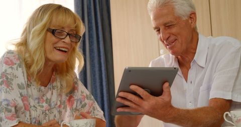 Senior Couple Enjoying Time with Tablet at Home
