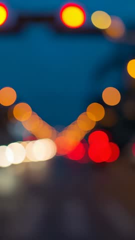 Vertical night traffic bokeh video glowing red signal and streaming car lights