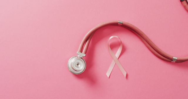 Depicts stethoscope and pink ribbon on pink background, symbolizing breast cancer awareness and prevention. Useful for campaigns, blogs, healthcare promotions, charity events, and educational materials on women's health.