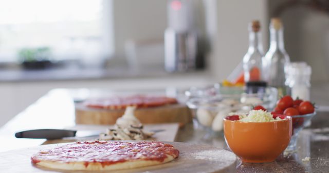 Image of pizza bases and bowls of tomatoes and grated cheese on counter in kitchen - Download Free Stock Photos Pikwizard.com