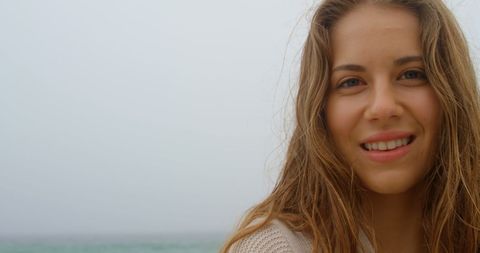 Smiling Young Woman Enjoying a Foggy Day by the Sea - Download Free Stock Images Pikwizard.com