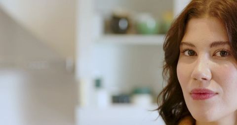 Woman in modern kitchen with stainless steel range hood