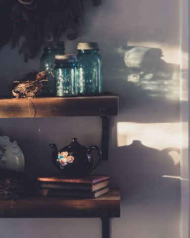 Cozy vintage kitchen corner with teapot, books and mason jars