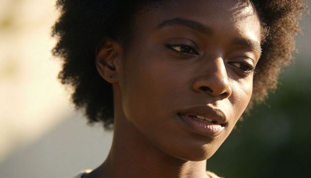 Sunlit portrait of woman turning head in garden, soft natural light, contemplative