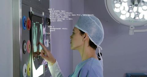 Surgeon examining spinal radiographs on illuminated lightbox in sterile surgical environment