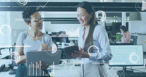 Diverse Colleagues Analyzing Data on Tablet in Modern Office