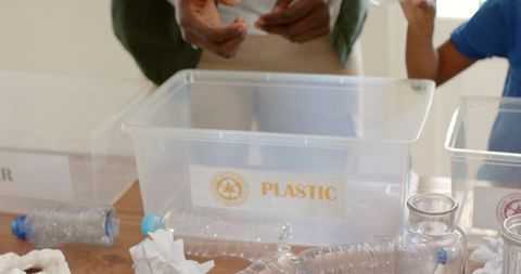 Sorting recyclables together: diverse adult and child sorting plastic bottles for community program