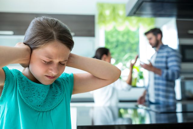 Sad Girl Covering Ears While Parents Arguing in Background - Download Free Stock Photos Pikwizard.com