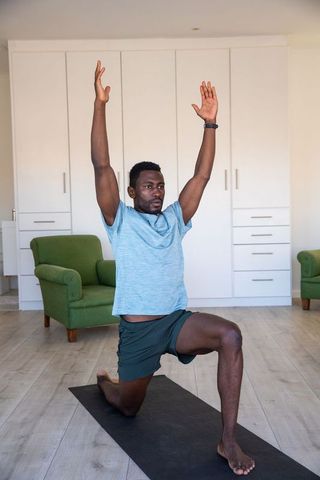 Man Executing Yoga Lunge in Modern Living Room
