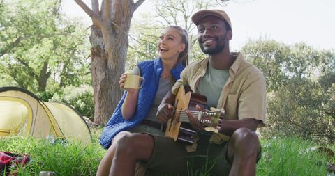 Happy Multiracial Couple Enjoying Music and Nature on Camping Trip
