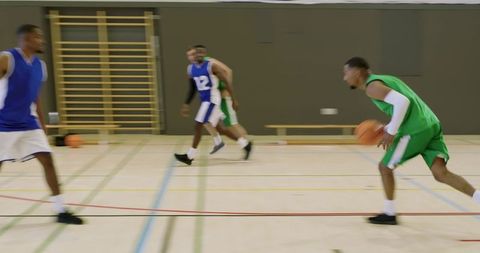 Fast-break basketball action african american guard dribbling attacking rim indoor gym