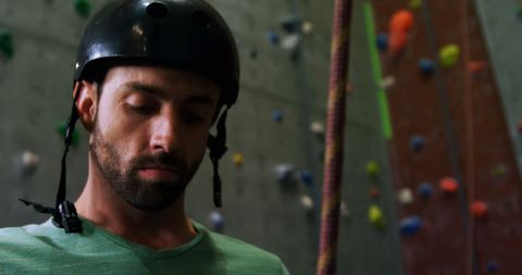 Focused man preparing for indoor rock climbing
