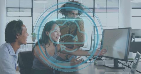 Multidisciplinary team collaborating on cloud data dashboard, pointing at analytics monitor