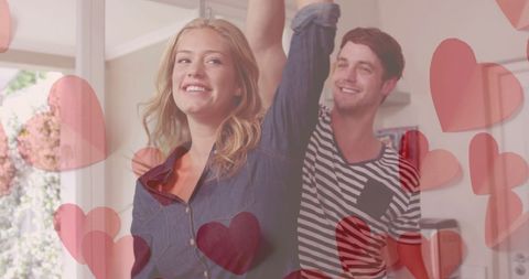 Joyful Couple Dancing at Home Surrounded by Hearts