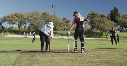 Female Cricket Players Preparing for Match on Sunny Day