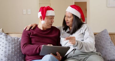 Senior Couple Shopping Online During Holidays in Cozy Living Room