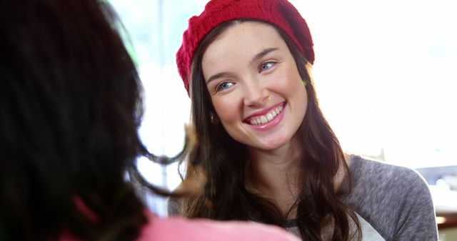 Woman smiling while interacting with friend in cafe 4k