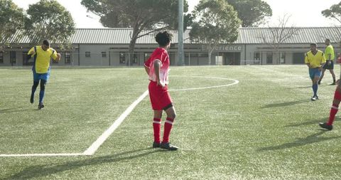 Soccer Player in Red Uniform Standing on Field During Day Match