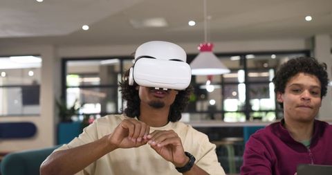 African American Student Using VR Headset While Collaborating in Modern Campus Lounge