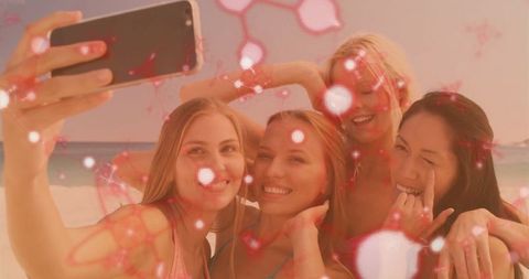 Cheerful Friends Capturing Beach Moments with Smartphone Shimmer