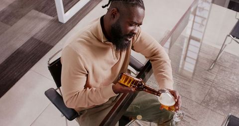 Businessman Relaxing with Beer in Office Environment