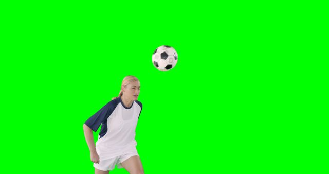 Sportswoman is playing football against a green screen 