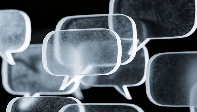 Floating frosted speech bubbles on black background, translucent acrylic dialogue concept