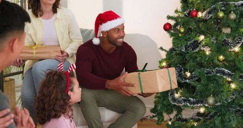 African American Man Celebrating Christmas with Family Near Tree