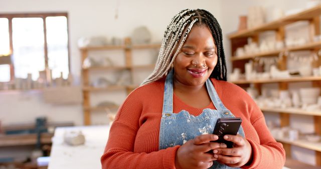 Smiling African American Female Artist Using Smartphone in Studio - Download Free Stock Images Pikwizard.com