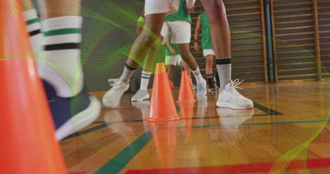 Basketball players in agility drill with cones in gymnasium