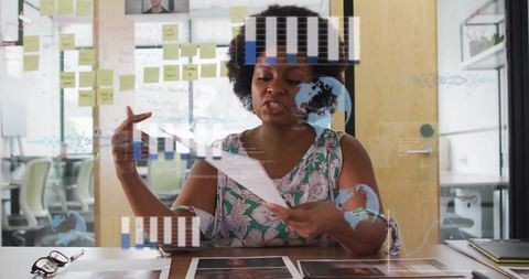 Creative professional reviewing print layouts and analyzing charts during team planning