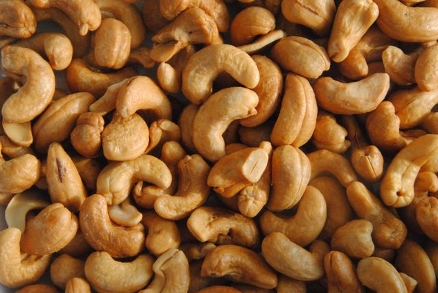 Close-up view of a pile of roasted cashew nuts. Ideal for use in health food blogs, recipes for healthy snacks, or advertisements for nutritional snacks. Can also be used for illustrating vegan and vegetarian dietary content.