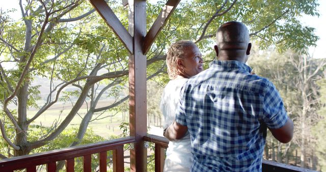 Back view of appy senior african american couple relaxing on sunny porch. Retirement, summer, relaxation, togetherness, domestic life and senior lifestyle, unaltered.