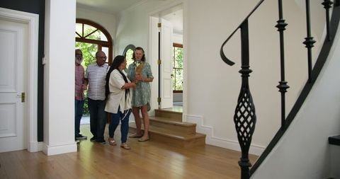 Senior Friends Gathering at Entrance With Wine and Flowers