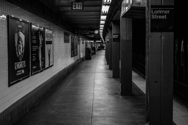 This black and white image of an empty subway platform at Lorimer Street captures the essence of urban solitude and ongoing life in the city underground. Perfect for use in projects related to public transportation, urban living, New York City, and metropolitan life. Can be used in travel blogs, urban studies, promotional materials for transportation services, or as a visual metaphor for solitude and quiet moments in bustling environments.