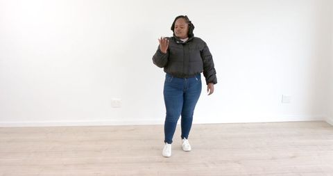 Confident woman in minimalist room displaying empowerment