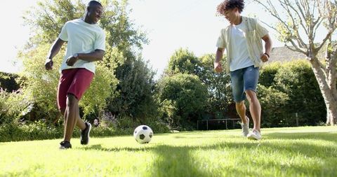 Two Friends Enjoying Soccer in Sunny Backyard