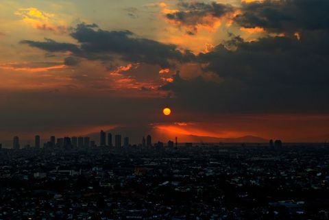 Majestic Sunset Over Urban Cityscape with Fiery Skies