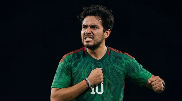 Shouting number 10 soccer player clenching fist to chest under stadium lights