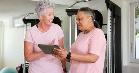 Senior Women Collaborating with Tablet in Home Gym