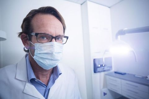 Confident male doctor wearing surgical mask in medical office