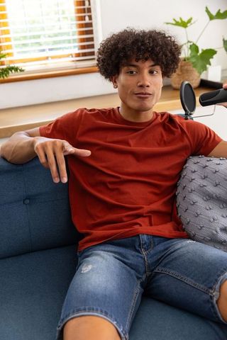 Casual Podcaster Speaking with Passion on Sofa in Modern Living Room