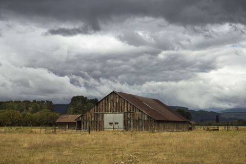 Rustic Barn Under Moody Skies in Countryside Landscape