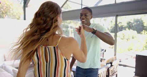 Joyful Couple Dancing Blissfully in Sunlit Living Room