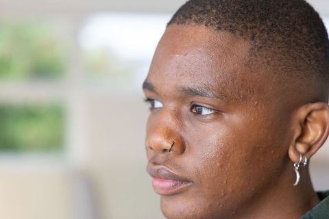 Contemplative African American Man Wearing Nose Hoop and Crescent Earring Close-Up Portrait