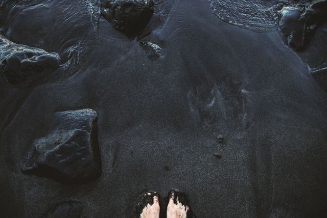 Bare Feet Standing on Black Sand Beach with Rocks - Download Free Stock Photos Pikwizard.com