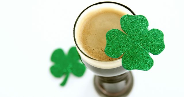 This image shows St. Patrick's Day theme with a cup of beer and glittery green shamrocks. Ideal for advertising promotions, Irish-themed parties, seasonal greetings, blog posts, or social media posts celebrating St. Patrick's Day.