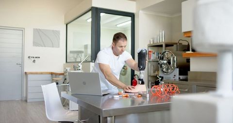 Technician calibrating prosthetic arm in modern workshop